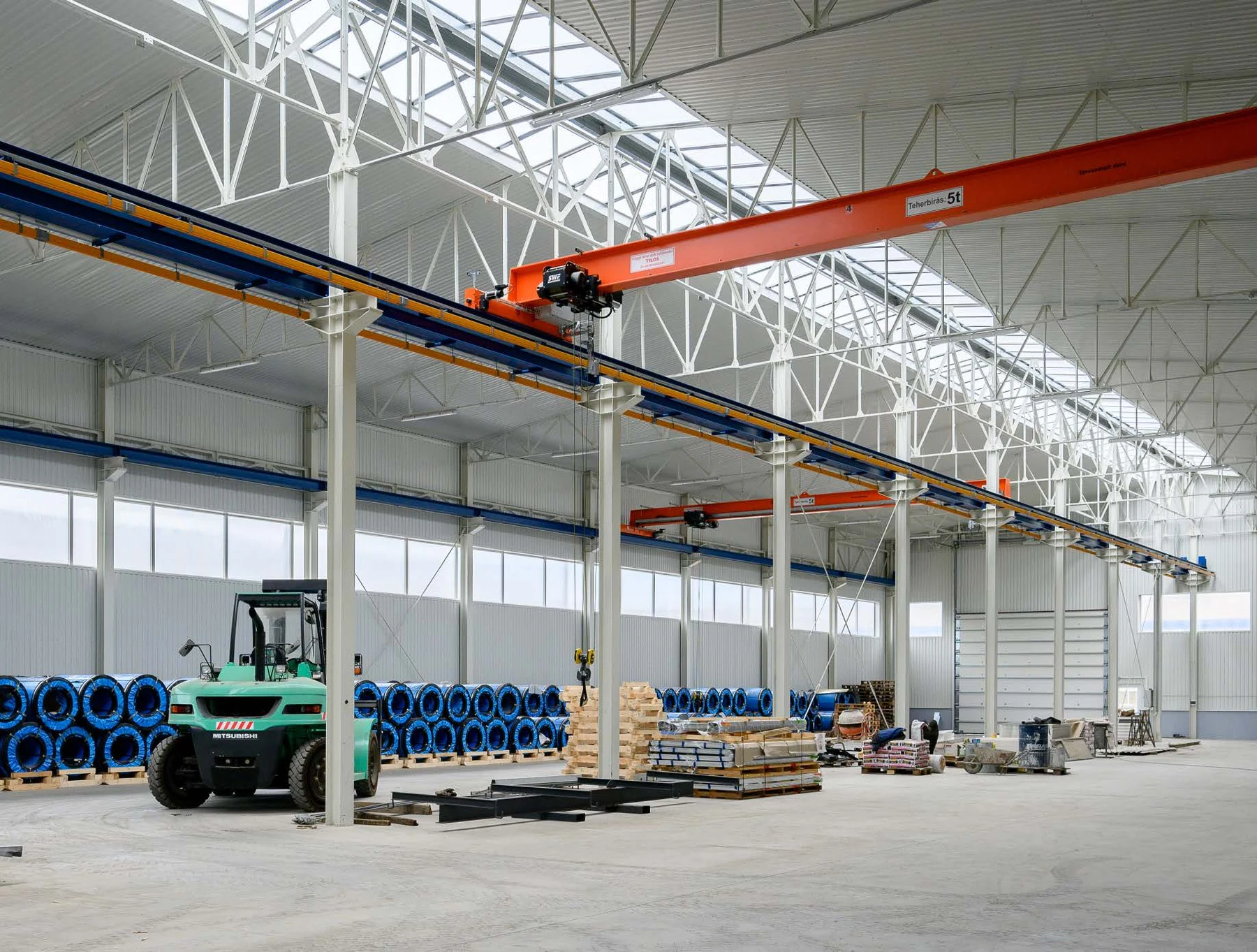 Industrial hall interior with overhead crane and forklift